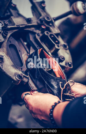 Le mani di un calzolaio esperto utilizzando una speciale macchina utensile per la realizzazione di calzature. La produzione di massa di calzature. Foto Stock