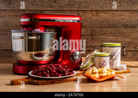 Mixer e gli ingredienti per la realizzazione di pirottini di pastella con ciliegie acide Foto Stock