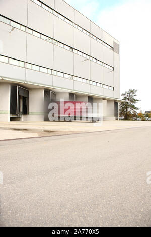 I lavoratori in un magazzino caricamento di un automobile Foto Stock