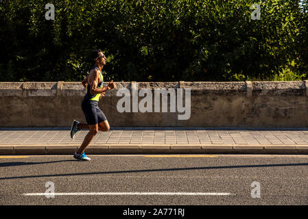 Valencia, Spagna - 27 Ottobre 2019: partecipante in una mezza maratona in esecuzione sull'asfalto della città di Valencia. Foto Stock