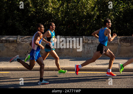 Valencia, Spagna - 27 Ottobre 2019: partecipante in una mezza maratona in esecuzione sull'asfalto della città di Valencia, nike vaporfly accanto Foto Stock