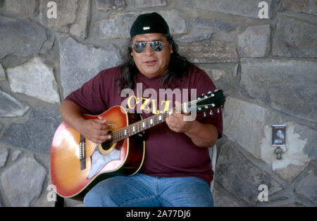 Un indiani Cherokee uomo suona la chitarra durante un festival culturale sulla prenotazione in North Carolina, USA. Foto Stock