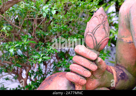 Buddha scultura in pietra mano closeup vista,tenendo una gemma di loto Foto Stock