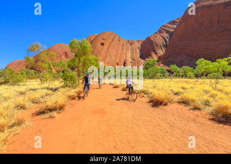 Uluru, territorio del Nord, Australia - 24 agosto 2019: Scoperta della famiglia Ayers Rock con giro in bicicletta lungo la passeggiata della base di Uluru a Uluru-Kata Tjuta Foto Stock
