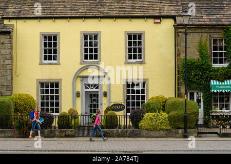 2 donne a piedi passato esterno di attraenti negozi di antiquariato (edificio Georgiano) & Dalesman Caffetteria Sala da tè - Villaggio di Gargrave, North Yorkshire, Inghilterra, Regno Unito Foto Stock