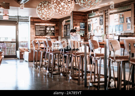 Tigard, Oregon - Ott 30, 2019 : Una donna seduta del cliente, cucina mangiare cibo all'interno di Whole Foods Market in Oregon Foto Stock