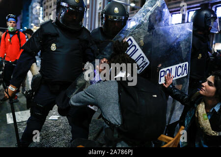 Madrid, Spagna. Xix oct, 2019. Spagnolo poliziotti antisommossa carica di un manifestante durante gli scontri.centinaia di estrema sinistra manifestanti si scontrano con la polizia dopo un rally del pacifico contro la Corte Suprema frase del catalano politica e attivisti. Essi sono stati più di dieci arresti e alcuni poliziotti sono stati feriti. In un tentativo di ricreare i violenti scontri di Barcellona i manifestanti si stabilirono barricades in alcune strade del centro citta'. Credito: Guillermo Santos SOPA/images/ZUMA filo/Alamy Live News Foto Stock