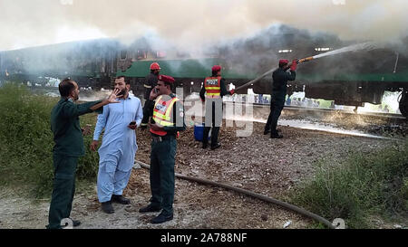 Rahim Yar Khan, Pakistan. 31 ott 2019. Foto scattate con un telefono mobile mostra i soccorritori cercando di spegnere un incendio di un treno passeggeri in Rahim Yar Khan distretto del Pakistan orientale della provincia del Punjab, Ott. 31. 2019. Almeno 10 persone sono state uccise e 16 altri feriti quando un treno passeggeri ha preso fuoco in Rahim Yar Khan distretto del Pakistan orientale della provincia del Punjab il giovedì, i media locali e i funzionari di detto. (Str/Xinhua) Credito: Xinhua/Alamy Live News Foto Stock