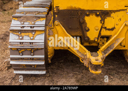 Close-up di bulldozer cingolato carrello. Movimento terra macchinari pesanti. Giallo macchine cingolate. Giallo sul trattore a cingoli, i cingoli del trattore Foto Stock