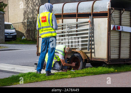 23 agosto 2019 Uomini in alta visibilità giacche la sostituzione di una ruota su un van per cavalli dail strada in Mullaghmore nella Contea di Sligo Irlanda Foto Stock