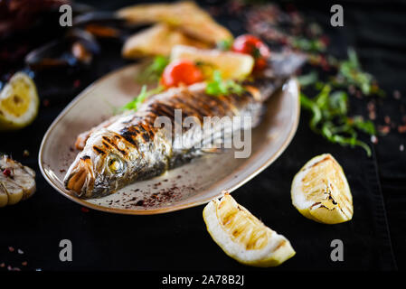 Deliicouse grigliate di pesce con verdure fresche e limone Foto Stock