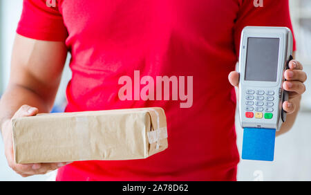 Consegna il pacco essendo pagato con pos e carta di credito Foto Stock