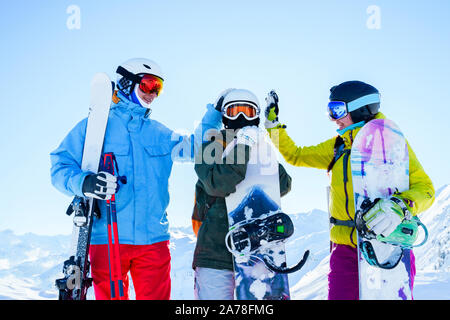 Immagine di tre atleti nel casco facendo stretta di mano alla neve località sul pomeriggio invernale Foto Stock