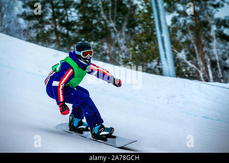 Il pilota maschio completare una discesa in snowboard racing Foto Stock