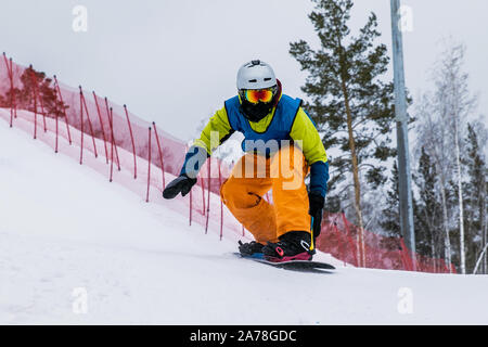 Atleta snowboarder in discesa una coperta di neve pendenza Foto Stock