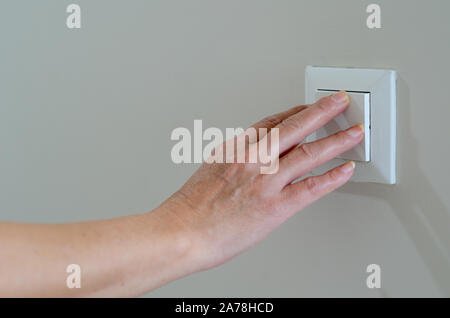 Stretta di mano donna per le curve degli interruttori della luce Foto Stock