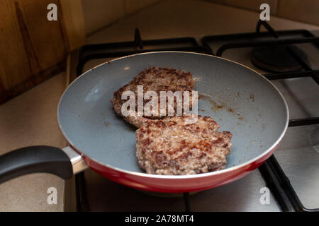 Quasi pronto hamburger di carne fritti in padella Foto Stock