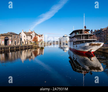 Leith, Edimburgo, Scozia, Regno Unito, 31 ottobre 2019. Regno Unito: Meteo caldo sole riflette gli edifici lungo la riva in acqua di Leith nonché Ocean Mist, una nave viene convertito in un lussuoso hotel galleggiante Foto Stock