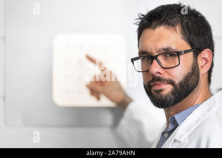 Medico oculista con lettera grafico conducendo un occhio di controllo Prova . Foto Stock