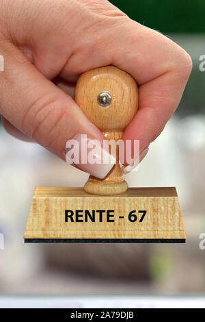 Mano mit Stempel, Frauenhand, Aufschrift: Rente mit 67 Foto Stock