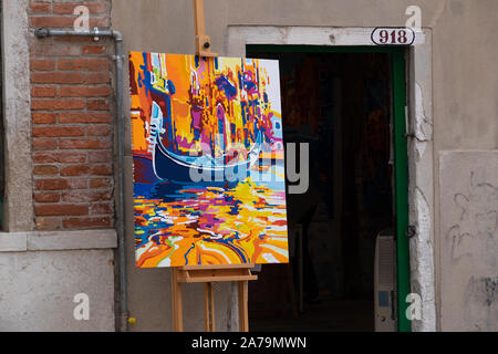 Vibrante dipinto originale olio dipinto in giallo, arancio e blu di una gondola sul canale visualizzato su un cavalletto in strada per pubblicizzare una galleria Foto Stock