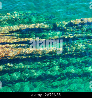 Superficie di acqua con ripple e roccioso di fondo del mare dal di sopra - naturale sfondo astratto Foto Stock