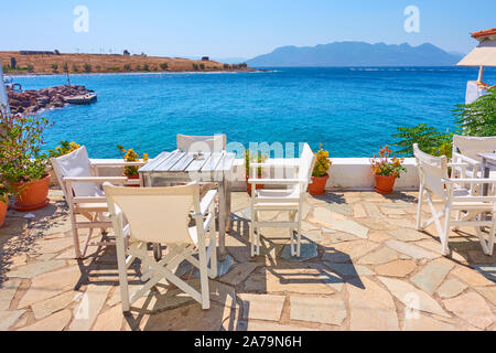 Tabelle di open-air cafe dal mare sulla soleggiata giornata estiva, Grecia Foto Stock