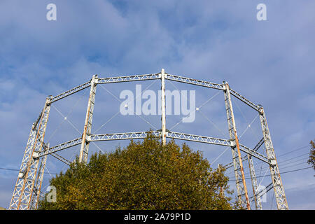 Arrugginimento gasometro contro un cielo blu con nuvole Foto Stock