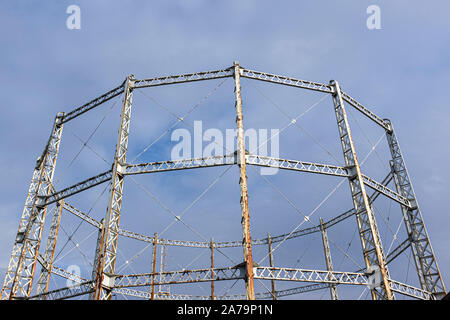 Arrugginimento gasometro contro un cielo blu con nuvole Foto Stock