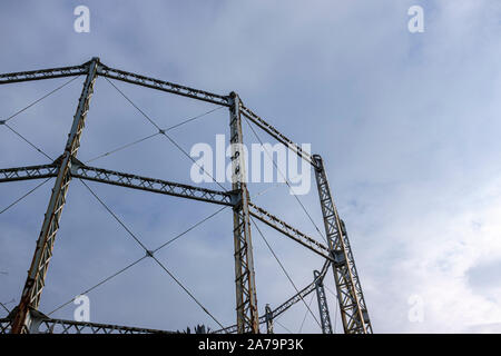 Arrugginimento gasometro contro un cielo blu con nuvole Foto Stock