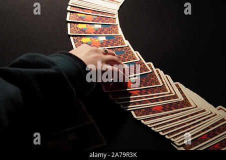 Boothbay Harbor, ME / STATI UNITI D'America - 20 Ottobre 2019: Il client sceglie le carte dal diffondersi durante una lettura dei tarocchi Foto Stock