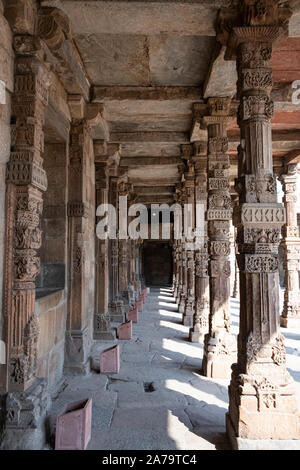 Intricate sculture in pietra sul chiostro colonne a Quwwat ul-Islam moschea, Qutb complessa, Delhi - pilastri presi dal tempio Jain. Foto Stock