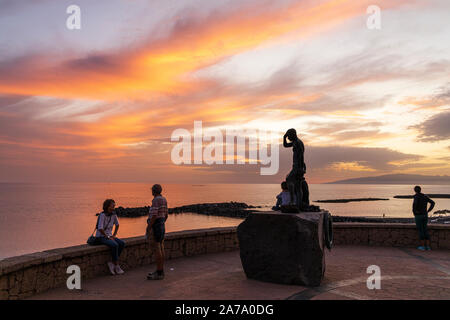 Guardare il tramonto dal belvedere sopra la Playa del Duque sulla Costa Adeje, Tenerife, Isole Canarie, Spagna Foto Stock