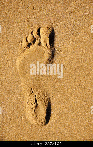 Spiaggia di sabbia, onde, camminando sulla spiaggia, orme nella sabbia. Foto Stock