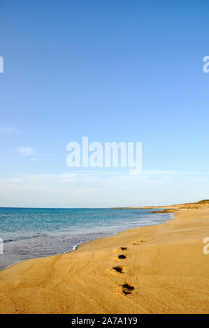 Spiaggia di sabbia, onde, camminando sulla spiaggia, orme nella sabbia. Foto Stock