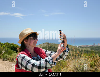 Attraente ragazza sorridente turista all'aperto prendendo un selfie Foto Stock