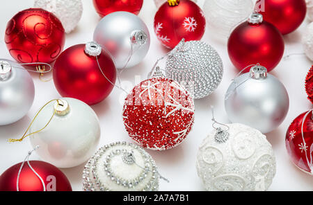 Decorazione di natale. Le palle di Natale di colore rosso e bianco colore contro uno sfondo bianco, primo piano Foto Stock