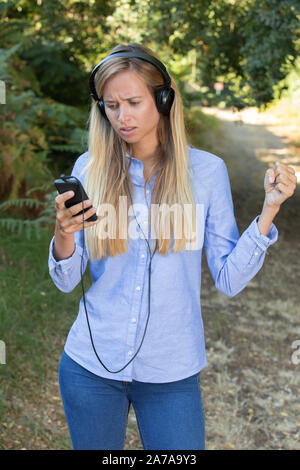 Donna escursionista ascoltando la musica nella foresta Foto Stock