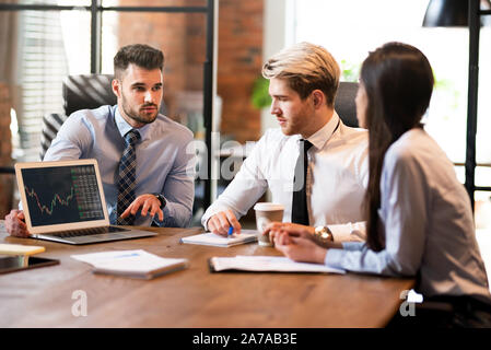 Un gruppo di giovani uomini di affari con computer portatile. Finanziari e contabili sulla discussione business meeting Foto Stock