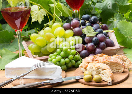 Vino rosso con gli occhiali e uva Foto Stock