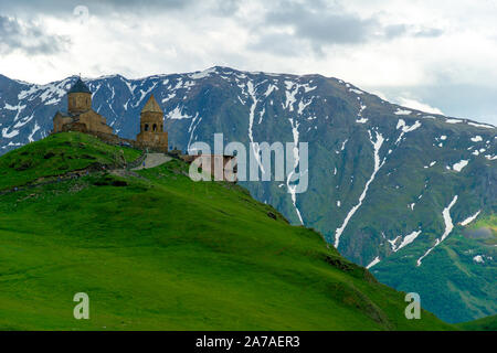 Gergeti Trinity Church noto anche come Tsminda Sameba sullo sfondo di un crinale e nuvole, Stepantsminda, Kazbegi, Georgia. Foto Stock