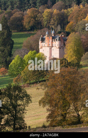 Castello di Craigievar in Aberdeenshire seduto su di una collina tra alberi visualizzando i loro vari colori autunnali Foto Stock