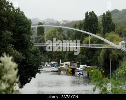 AJAXNETPHOTO. 2019. PORT MARLY, Francia. - Ponte sul Fiume Senna - un nuovo pedoni e ciclisti PASSARELLE ponte che attraversa il fiume Senna a PORT MARLY torreggia sopra il vecchio PENICHE case galleggianti ormeggiate alla riva del fiume. Xix secolo artisti impressionista Alfred Sisley, Camille Pissarro, Claude Monet, Auguste Renoir, Corot, NONCHÉ FAUVIST pittori espressionisti André Derain, MAURICE DE VLAMINCK e altri studi fatti di vita sul fiume qui vicino. Il ponte, completata nel 2016, misure di 86m di lunghezza e pesa 131 tonnellate.foto:JONATHAN EASTLAND/AJAX REF:GX8 192609 554 Foto Stock