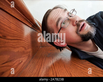 Uomo è caduto su scale guardando verso l'alto fuori del telaio Foto Stock