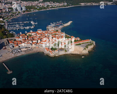 VISTA AEREA. Città medievale su un promontorio roccioso. Budva, Montenegro. Foto Stock