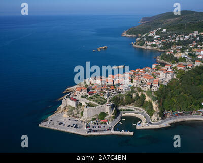 VISTA AEREA. Città storica su un promontorio roccioso sopra il Mare Adriatico. Ulcinj, Montenegro. Foto Stock