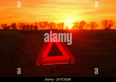 Triangolo di segnalazione da ripartiti in auto sulla strada di campagna al tramonto york regno unito Foto Stock