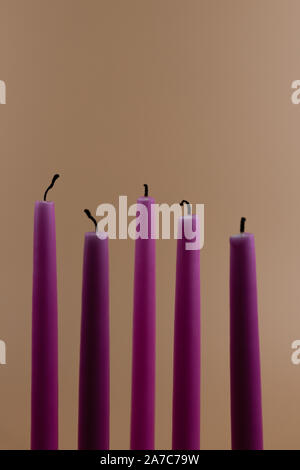 Candele bruciate, isolate su sfondo arancione sbiadito Foto Stock