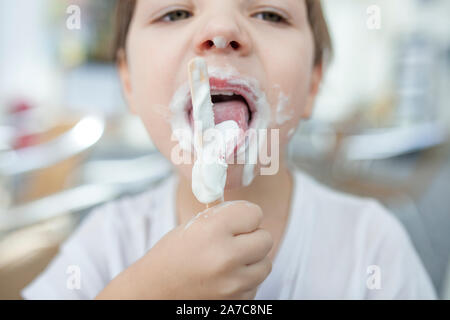 4 anni vecchio ragazzo godendo di un bastoncino di gelato. Messa a fuoco selettiva Foto Stock