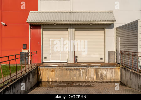 Storage porta per lo scarico del carico può essere usata come background industriale. Portelli di carico a magazzino o negozio di baia di carico Foto Stock